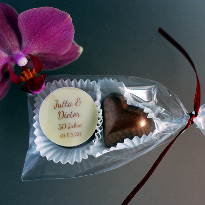 Hochzeitspraline und bronzenes Herz verpackt im Tütchen